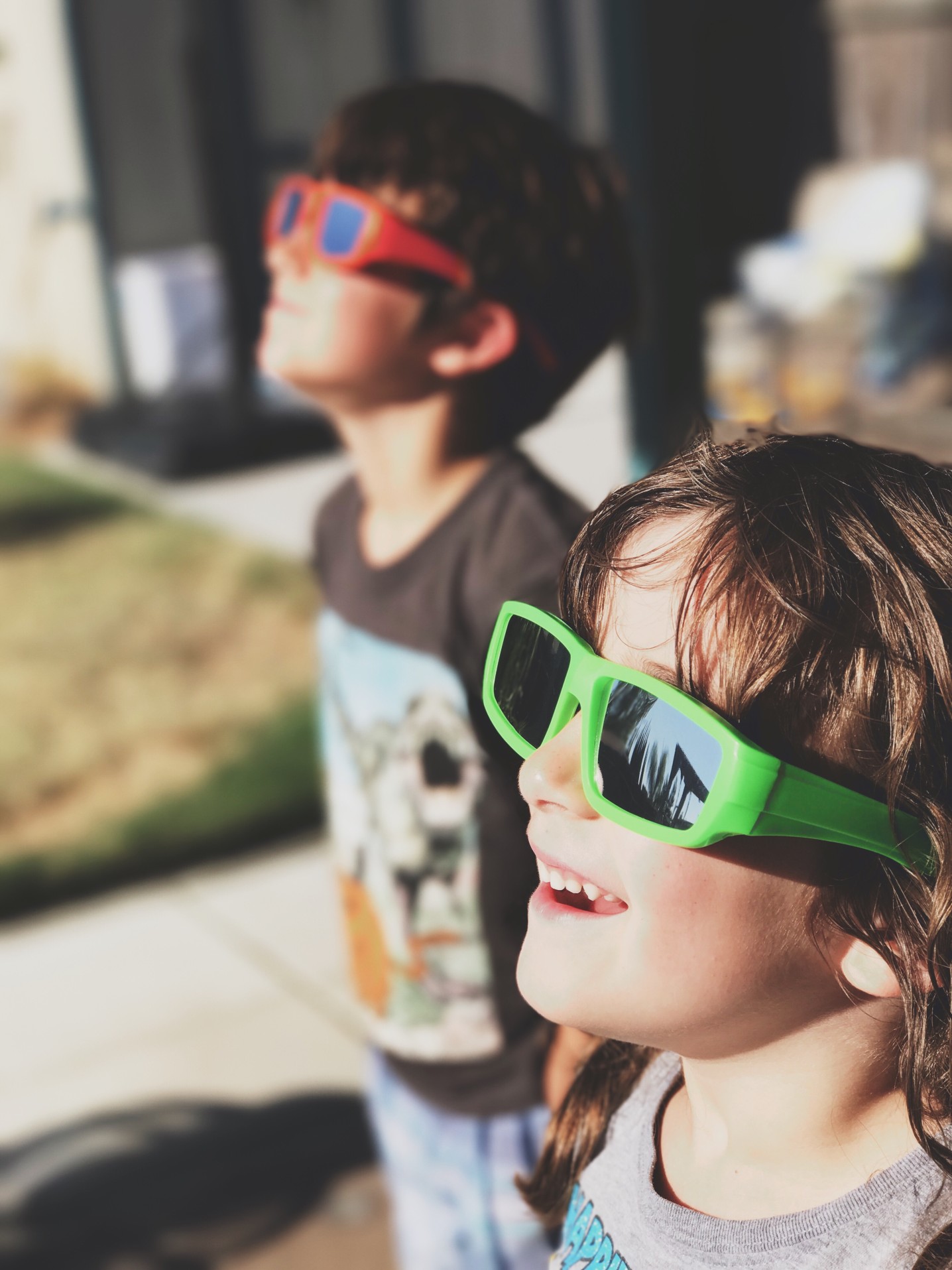 Kids looking through solar glasses.
